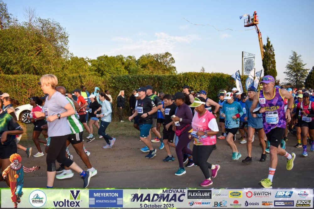 A wide shot of the MadMac start-line field running past Café du Cirque